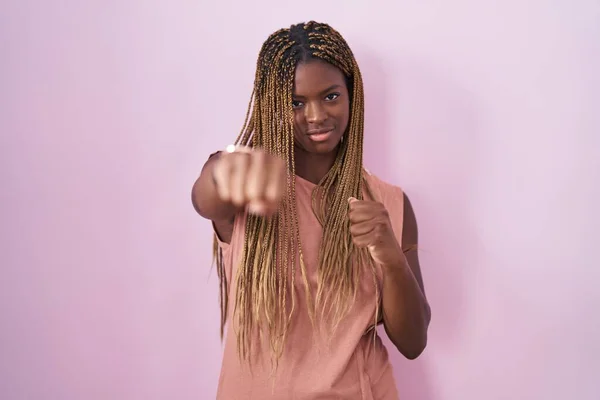 一头辫子的非裔美国妇女站在粉色背景的基础上 握拳打斗 攻击性和愤怒的攻击 威胁和暴力 — 图库照片