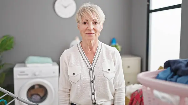 Middelbare Leeftijd Blonde Vrouw Stand Waslijn Met Ontspannen Uitdrukking Wasruimte — Stockfoto