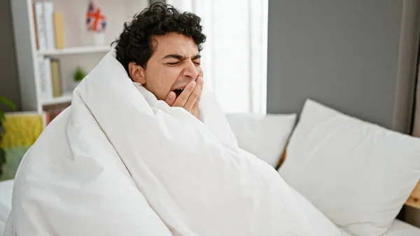 Genç Latin Adam Yatakta Oturuyor Yatak Odasında Battaniyeyle Esniyor — Stok fotoğraf