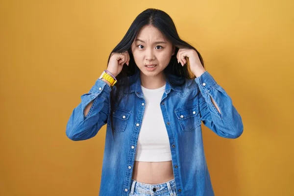 Jonge Aziatische Vrouw Die Gele Achtergrond Oren Bedekt Met Vingers — Stockfoto