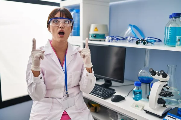Young Brunette Woman Working Scientist Laboratory Amazed Surprised Looking Pointing — Foto Stock