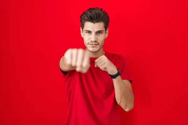 Young Hispanic Man Standing Red Background Punching Fist Fight Aggressive — ストック写真