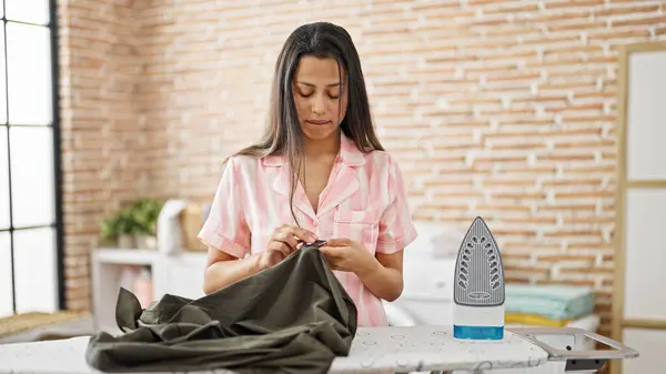 Young Beautiful Hispanic Woman Reading Shirt Label Laundry Room — Stock Photo, Image