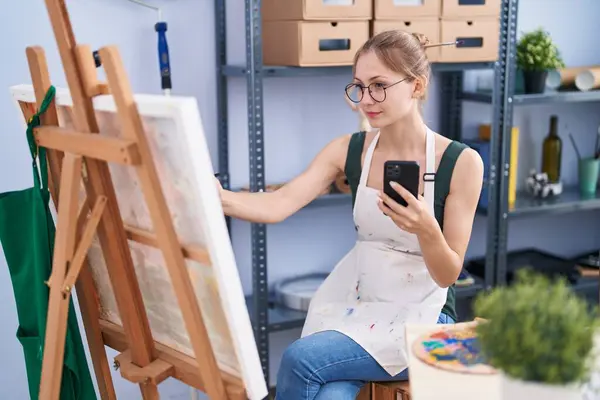 年轻的高加索女艺术家在艺术工作室用智能手机绘图 — 图库照片