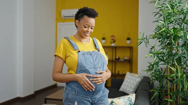 Junge Schwangere Frau Lächelt Selbstbewusst Und Berührt Bauch Hause — Stockfoto