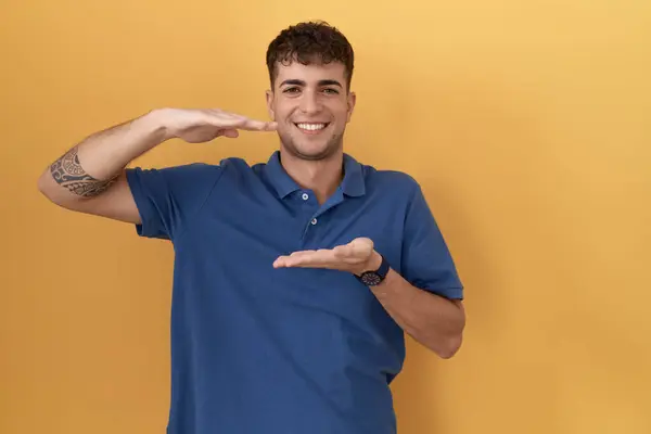 Young Hispanic Man Standing Yellow Background Gesturing Hands Showing Big — Stock Photo, Image