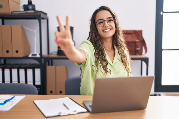 Ofiste Çalışan Gözlüklü Gülümseyen Parmaklarını Zafer Işareti Yaparken Gösteren Genç — Stok fotoğraf