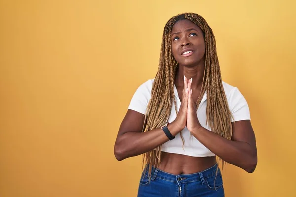Африканская Американка Плетеными Волосами Стоящая Желтом Фоне Умоляя Молясь Руками — стоковое фото