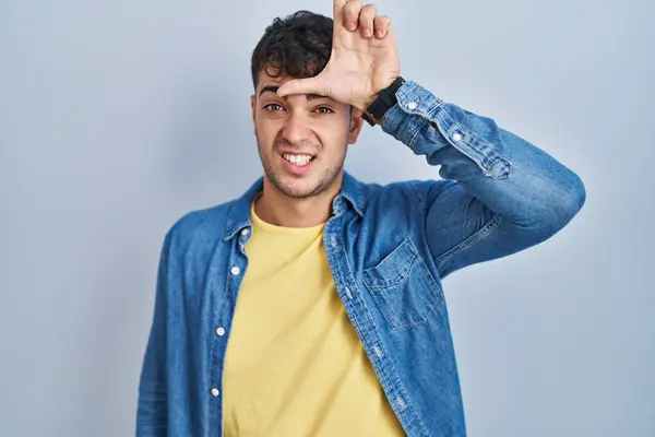 Young Hispanic Man Standing Blue Background Making Fun People Fingers — Φωτογραφία Αρχείου