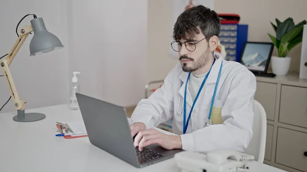 Young Hispanic Man Doctor Using Laptop Working Clinic — Stockfoto
