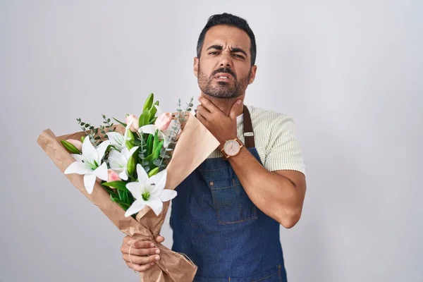 Hispanic man with beard working as florist touching painful neck, sore throat for flu, clod and infection