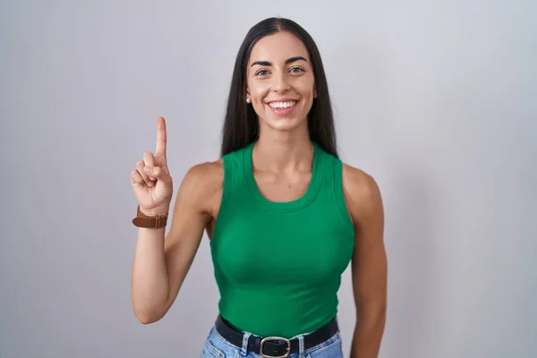 Young Woman Standing Isolated Background Showing Pointing Finger Number One — Stockfoto
