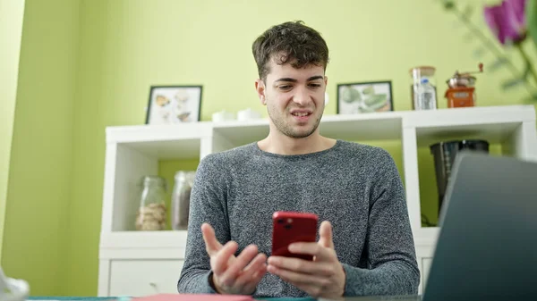 Νεαρός Ισπανός Που Χρησιμοποιεί Smartphone Και Laptop Και Δείχνει Αναστατωμένος — Φωτογραφία Αρχείου