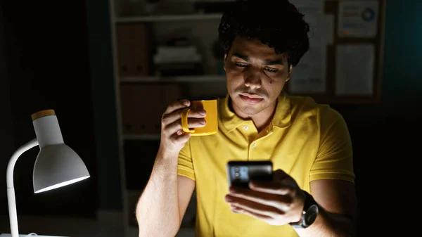 Genç Latin Adamı Akıllı Telefon Kullanıyor Ofiste Kahve Içiyor — Stok fotoğraf