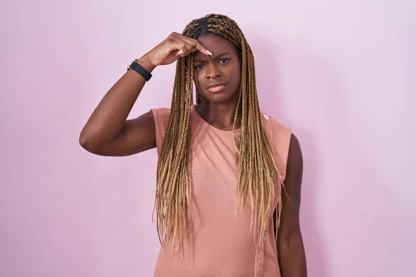 黑头发的非裔美国女人站在粉色的背景上 不高兴地指出额头上的粉刺 丑陋的黑头发感染 粉刺和皮肤问题 — 图库照片