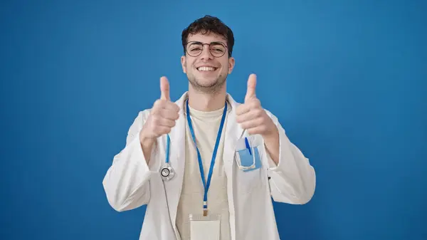 Junger Hispanischer Arzt Macht Daumen Hoch Über Isoliertem Blauem Hintergrund — Stockfoto