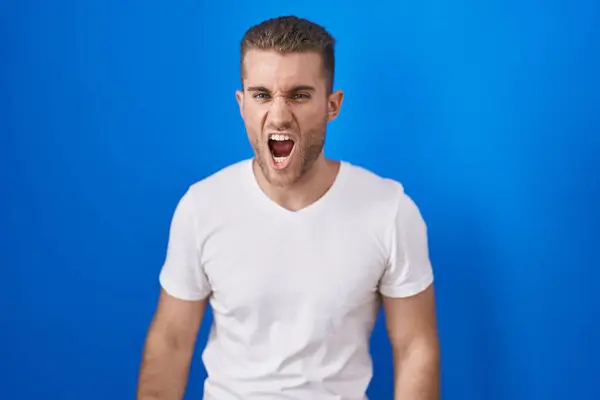 Young Caucasian Man Standing Blue Background Angry Mad Screaming Frustrated — стоковое фото