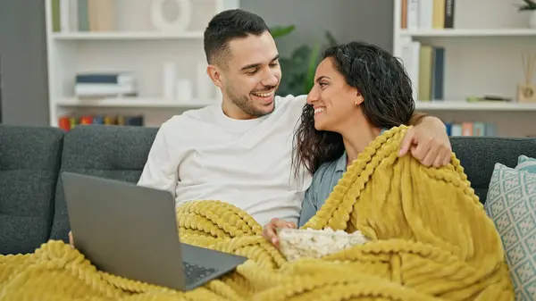 Man and woman couple watching movie on laptop at home