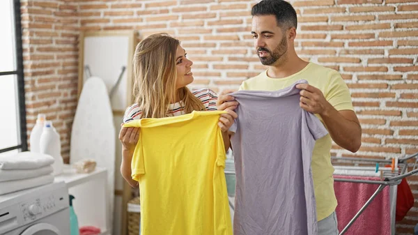 Man and woman couple looking t shirts at laundry room