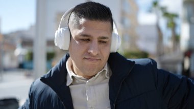 Sokak ortasında müzik dinleyen ve dans eden genç bir İspanyol.