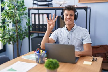 Ofiste çalışan, kulaklık takan, dört numaralı parmaklarıyla işaret eden, kendinden emin ve mutlu genç İspanyol bir adam.. 