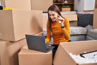 Kafkasyalı genç bir kadın yeni evinde video kaydı tutuyor.