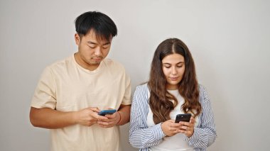 Kadın ve erkek, izole edilmiş beyaz arka plan üzerinde ciddi ifadeleri olan akıllı telefonlar kullanıyor.