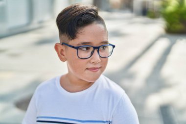 Sevimli İspanyol çocuk ciddi bir ifadeyle sokağa bakıyor.