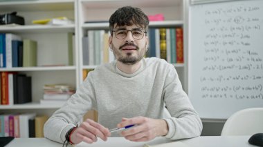 Üniversite sınıfında masa başında matematik öğretmenliği yapan genç bir İspanyol.