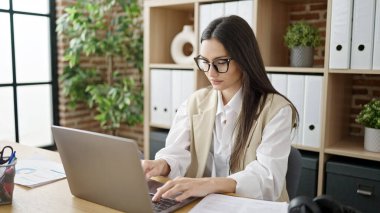 Young beautiful hispanic woman business worker using laptop working at office