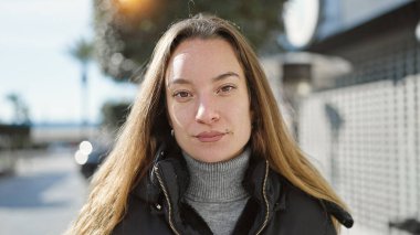 Young caucasian woman standing with serious expression at street
