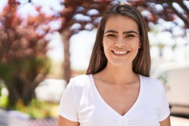 Young woman smiling confident looking to the camera at park