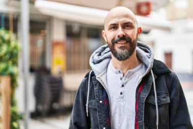 Genç kel adam gülümsüyor. Kendine güveniyor.