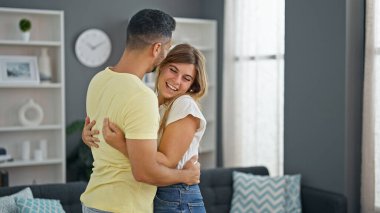 Erkek ve kadın çift evde birbirlerine sarılıyorlar.