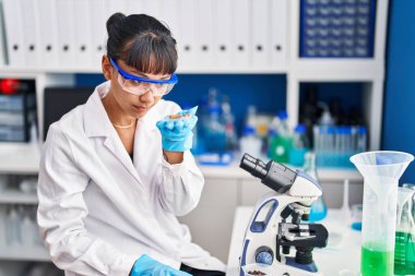 Genç ve güzel İspanyol bilim kadını laboratuarda haplar tutuyor.