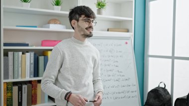 Genç İspanyol erkek öğretmen üniversite sınıfında matematik dersi veriyor.