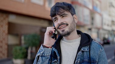 Genç İspanyol adam kahve dükkanının terasında telefonla konuşuyor.