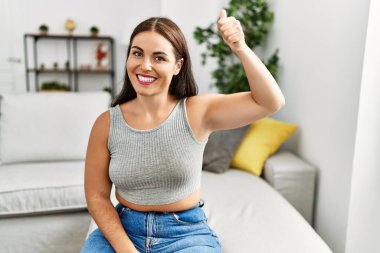 Genç ve güzel İspanyol kadın evdeki kanepede oturan sağırlarla iletişim kuruyor.