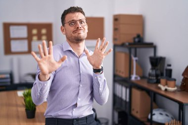 Ofisteki korkmuş ve korkudan dehşete düşmüş genç İspanyol adam elleriyle hareket etmeyi kes, şok içinde bağır. panik konsepti. 