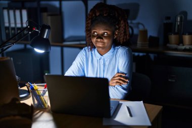 Geceleri ofiste çalışan Afrikalı bir kadın gülümseyip yan tarafa bakıyor ve şöyle düşünüyor:. 