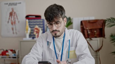 Genç İspanyol doktor, klinikte çalışan akıllı telefonu kullanıyor.