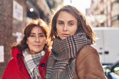İki kadın anne ve kız sokakta rahat bir ifadeyle yan yana duruyorlar.