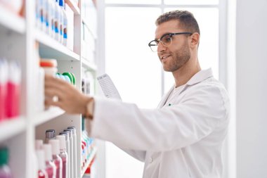 Eczanede kendinden emin gülümseyen beyaz bir eczacı.