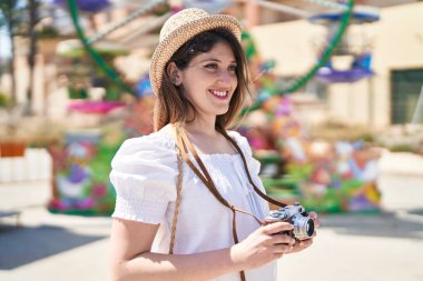 Young hispanic woman tourist smiling confident using camera at street