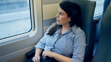 Genç, güzel İspanyol kadın mutlu bir şekilde gülümsüyor. Tren vagonunun içinden bakıyor.