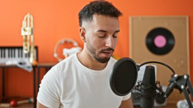 Genç Arap müzisyen müzik stüdyosunda şarkı söylüyor.