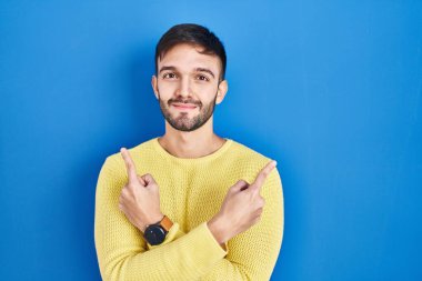 Mavi arka planda dikilen İspanyol adam iki tarafı da parmaklarıyla işaret ediyor. Farklı yönler farklı. 