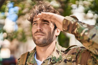 Young man army soldier doing militar salute at park