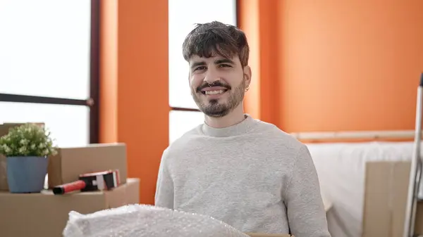 Junger Hispanischer Mann Lächelt Zuversichtlich Und Hält Paket Neuen Zuhause — Stockfoto