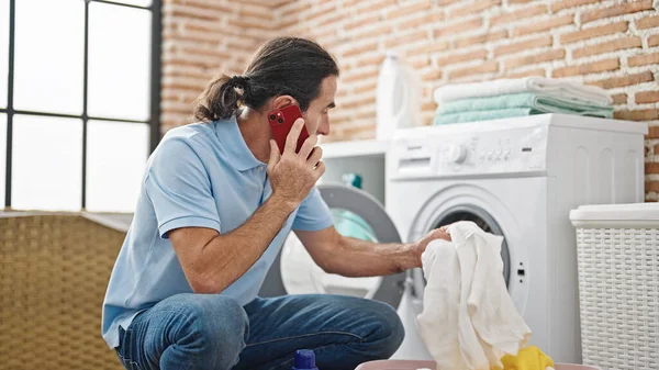 Çamaşır Odasında Çamaşır Yıkayan Orta Yaşlı Bir Adam Akıllı Telefondan — Stok fotoğraf